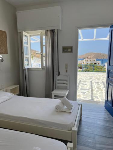 a hotel room with two beds and a balcony at Pension Irene in Ios Chora
