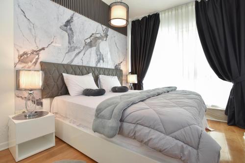 a bedroom with a large bed with a marble wall at Luxury one bedroom apartment in beachfront apart Hotel in Budva