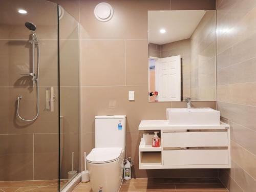 a bathroom with a shower and a toilet and a sink at Sea view 5 bedroom holiday house in Whangaparaoa