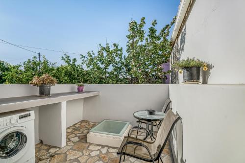 a small balcony with a table and a washing machine at Angel’s studio in Potamós