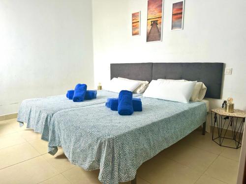 une chambre avec un lit avec des oreillers bleus dessus dans l'établissement Sunny Apartment, à Puerto del Carmen