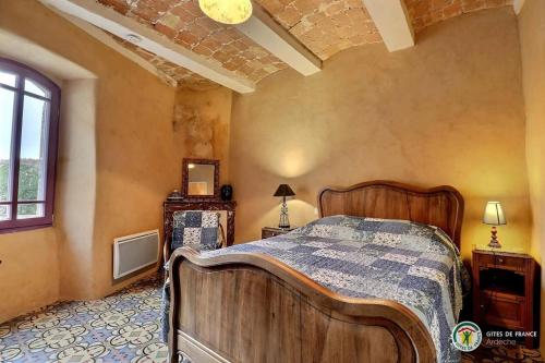 une chambre avec un lit en bois dans une pièce dans l'établissement Domaine de Peyre Brune - Gîte de charme en Ardèche du sud, à Beaulieu
