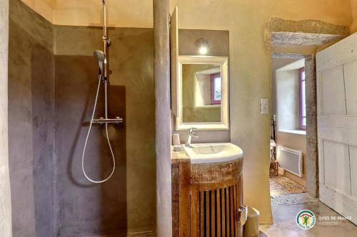 une salle de bain avec un lavabo et un miroir dans l'établissement Domaine de Peyre Brune - Gîte de charme en Ardèche du sud, à Beaulieu