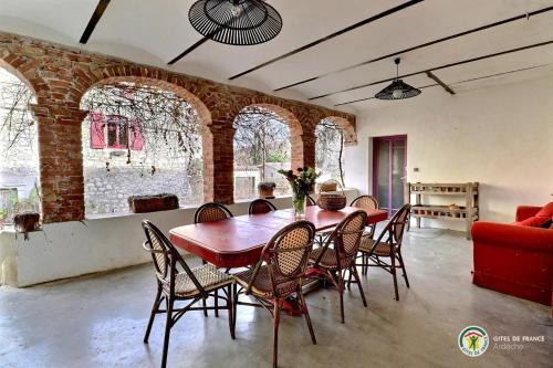 une salle à manger avec une table et des chaises rouges dans l'établissement Domaine de Peyre Brune - Gîte de charme en Ardèche du sud, à Beaulieu