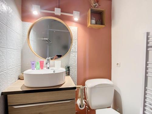 ein Badezimmer mit Waschbecken, Spiegel und Toilette in der Unterkunft Charmante maison in Joux-la-Ville