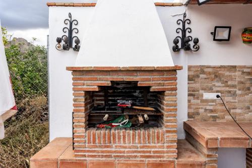 ein gemauerter Außenkamin mit weißem Dach in der Unterkunft MalagaSuite Casa Rural Alcaucin in Alcaucín