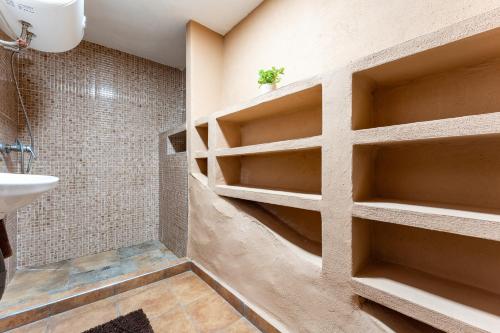 a bathroom with shelves on the wall at MalagaSuite Villa Rural Alcaucín in Alcaucín