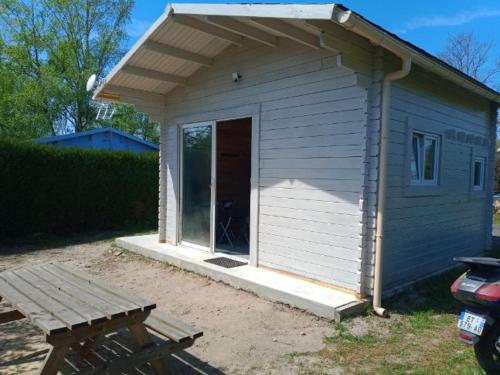 un petit hangar bleu avec un porche et une porte dans l'établissement chalet tout confort, à Coullons
