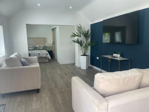 a living room with two white couches and a bedroom at The Old Stable, Rustic Charm Modern Comforts in Gorfield