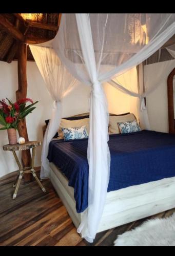 a bedroom with a bed with a canopy at Nueva onda in Palomino