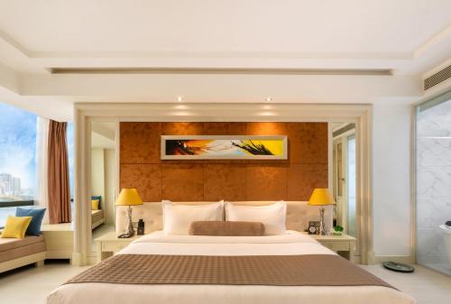 a bedroom with a large bed and a couch at Brilliant Hotel - Afternoon Tea Inclusive in Da Nang