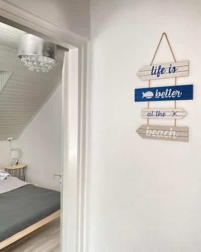 a room with a sign that reads life is better at the beach at Mária Full house in Balatonmáriafürdő