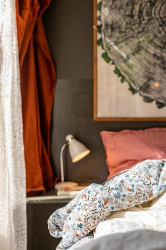 une chambre avec un lit et une lampe sur une table dans l'établissement Les Cabanes Des Marais, à La Madelaine-sous-Montreuil