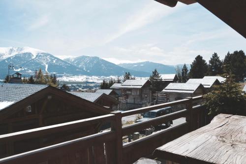 une vue sur les montagnes enneigées depuis un balcon en bois dans l'établissement Chalets Collection Granges - Les Chalets Secrets, à Bolquère-Pyrénées 2000