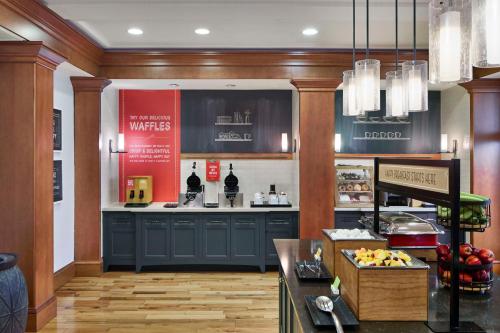a large kitchen with blue cabinets and a counter at Hampton Inn & Suites Saratoga Springs Downtown in Saratoga Springs