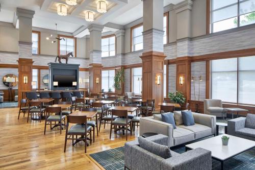 a restaurant with tables and chairs and a television at Hampton Inn & Suites Saratoga Springs Downtown in Saratoga Springs