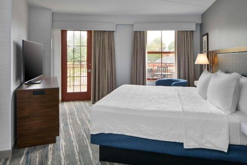 a hotel room with a bed and a flat screen tv at Hampton Inn & Suites Saratoga Springs Downtown in Saratoga Springs