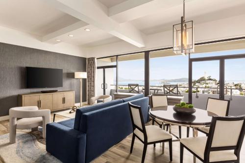 a living room with a table and chairs and a television at Hilton San Francisco Financial District in San Francisco