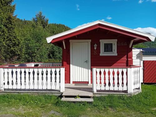 a red and white house with a white fence at Nordnes Kro og Camping in Rokland