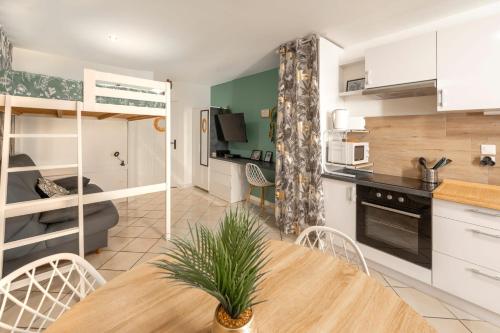 a kitchen and living room with a table and chairs at Urban Jungle PARKING & Netflix Centre historique in Manosque