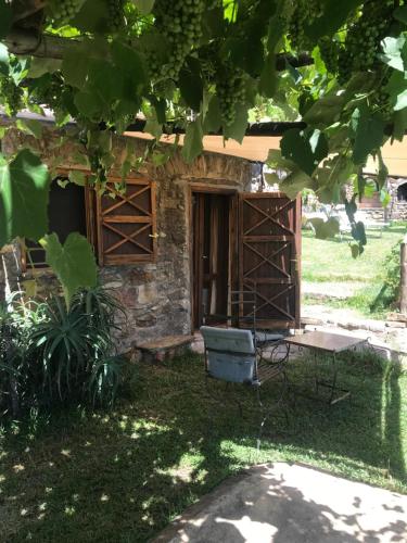 a stone house with a table and a chair in the yard at Il Mandorlo in Montecorice