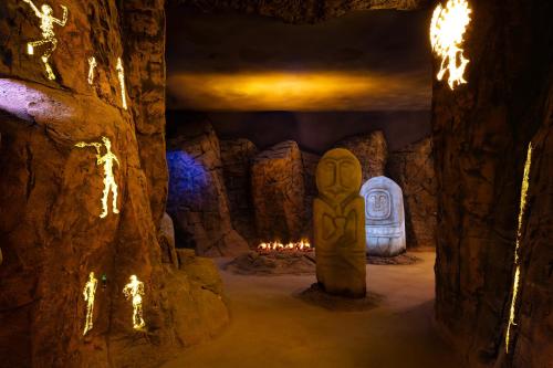 a cave with a stone statue in front of a fireplace at KARAVANSARAY Turkistan Family Hotel - FLYING THEATRE ACCESS in Türkistan