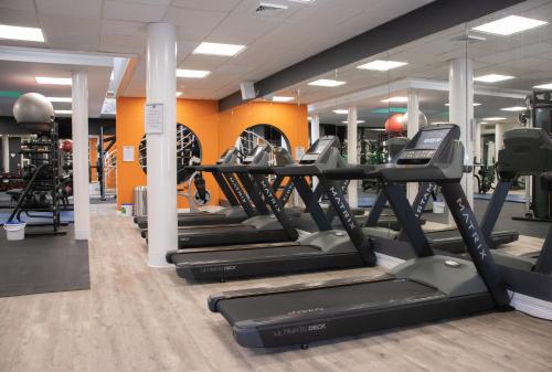 a gym with treadmills and elliptical machines at Manor Of Groves Hotel, Golf & Health Club in Sawbridgeworth