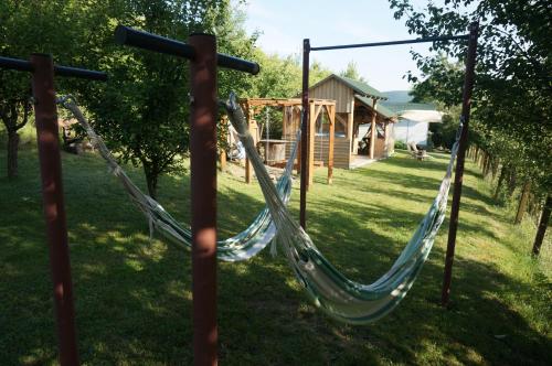 a hammock in a yard with a house at Natura Chalets in Praid