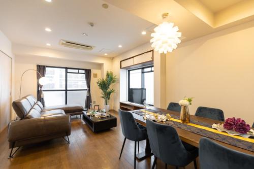 a dining room and living room with a table and chairs at なんば各駅徒歩圏内 団体予約可能 GroundCourt難波 心斎橋 道頓堀 黒門市場 in Osaka