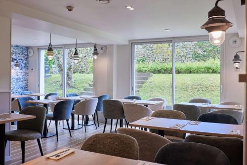 a restaurant with tables and chairs and a window at Quality Hotel La Marebaudière Vannes Centre in Vannes