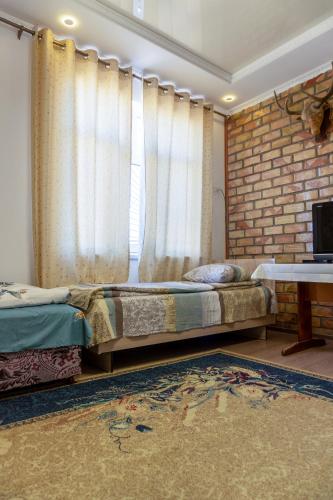 a bedroom with a bed and a window with curtains at Guest house and yurt camp Svetlana in Bokonbayevo