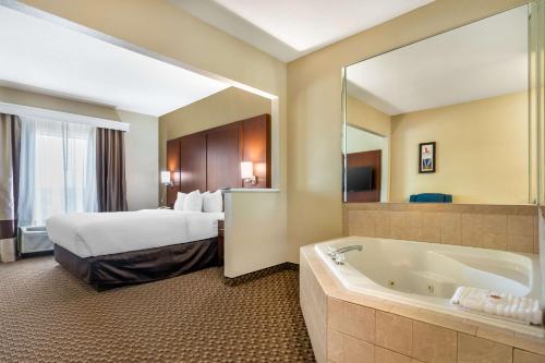 a hotel room with a bed and a bath tub at Comfort Suites - Jefferson City in Jefferson City
