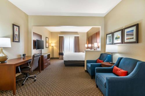 a hotel room with a bed and a desk at Comfort Suites - Jefferson City in Jefferson City