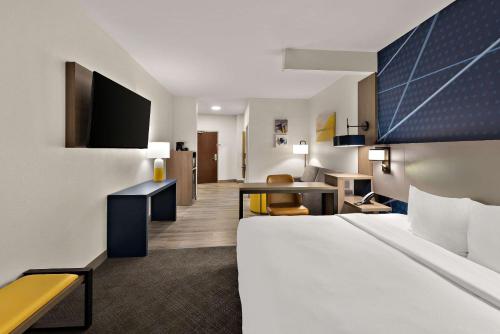 a hotel room with a bed and a desk at Comfort Suites Columbus East Broad in Columbus