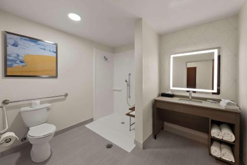 a bathroom with a toilet and a sink and a mirror at Comfort Suites Columbus East Broad in Columbus