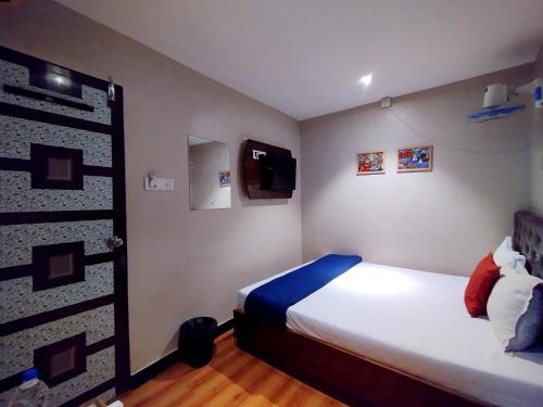 ムンバイにあるHotel Aspenのベッドとテレビのある小さな寝室