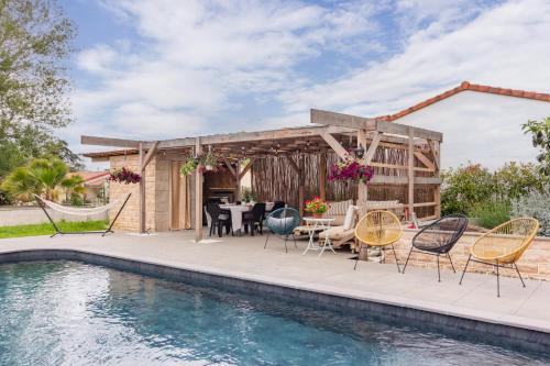 un patio avec une table et des chaises à côté d'une piscine dans l'établissement Belle maison familiale avec piscine privée, à Lézat-sur-Lèze