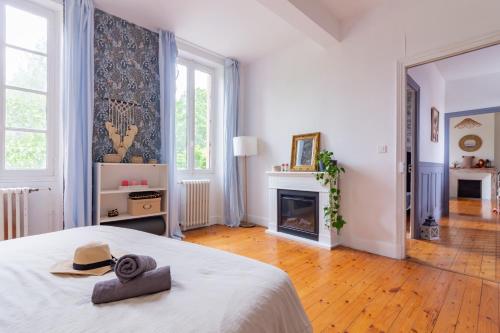 une chambre blanche avec un lit et une cheminée dans l'établissement Belle maison familiale avec piscine privée, à Lézat-sur-Lèze