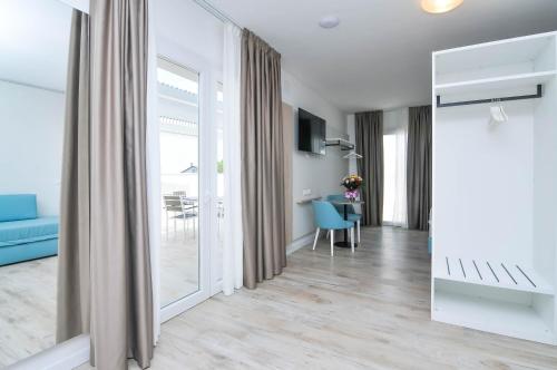 a living room with a blue couch and a mirror at Marina Palace Hotel 4 stelle S in Caorle
