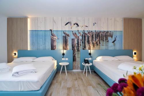 a bedroom with two beds and a painting on the wall at Marina Palace Hotel 4 stelle S in Caorle