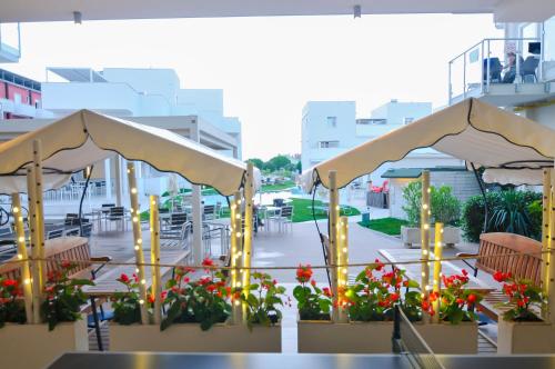 a patio with a bunch of flowers and umbrellas at Marina Palace Hotel 4 stelle S in Caorle