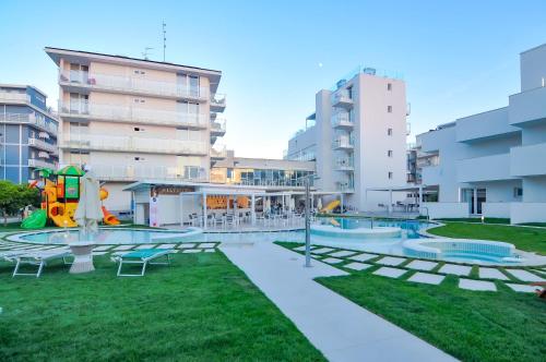 an apartment complex with a pool and a playground at Marina Palace Hotel 4 stelle S in Caorle