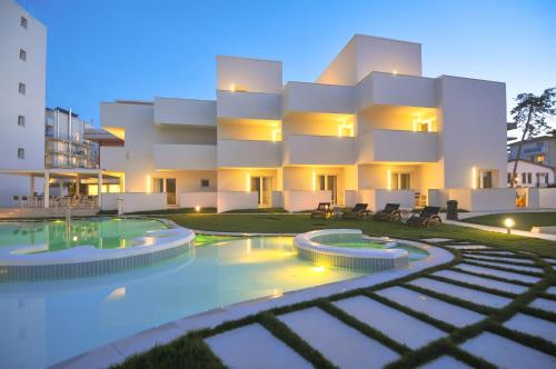 a large building with a swimming pool in front of it at Marina Palace Hotel 4 stelle S in Caorle