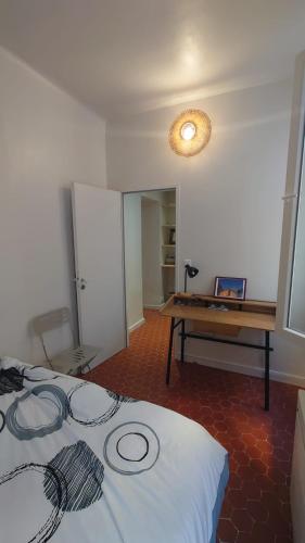 Cette chambre comprend un lit et un bureau. dans l'établissement Appartement de charme - WIFI - Centre historique, à Toulon