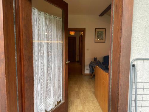 a door to a living room with a window at Mansarda Mulaz in Falcade
