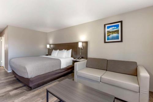 a hotel room with a bed and a couch at Quality Inn Show Low in Show Low