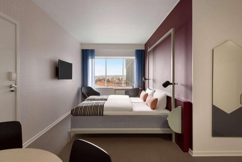a hotel room with a bed and a window at Comwell Aarhus Dolce by Wyndham in Aarhus