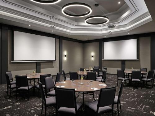 a conference room with tables and chairs and blank screens at Hyatt Place Montreal - Downtown in Montréal