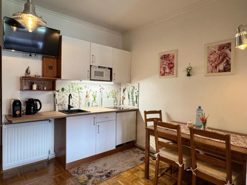 a kitchen with white cabinets and a table and chairs at Landhaus Klopein in Sankt Kanzian