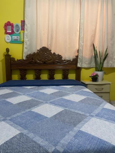 a bedroom with a blue and white bed with a window at Cantinho dos pássaros in Coronel Fabriciano